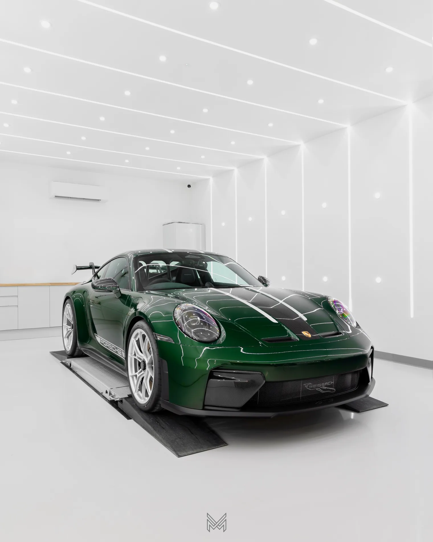 A dark green Porsche 911 GT3 Weissach in the Meraki Motorworks studio